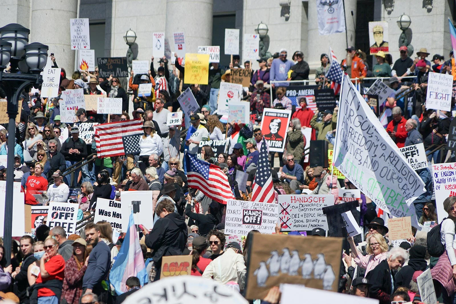 crowd protesting with signs and flags