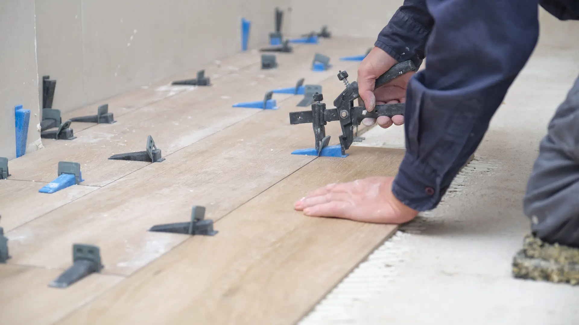 mason hands adjusting tile levelers between