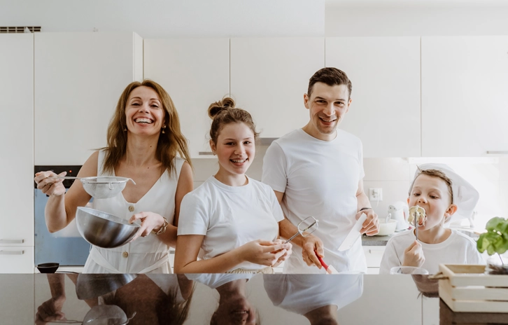 Happy family of four in the kitchen