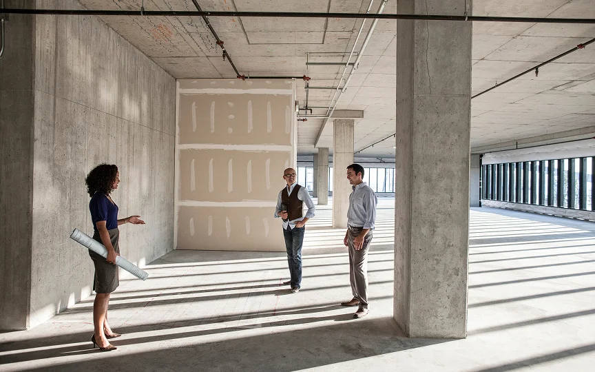 business people touring a new empty raw building