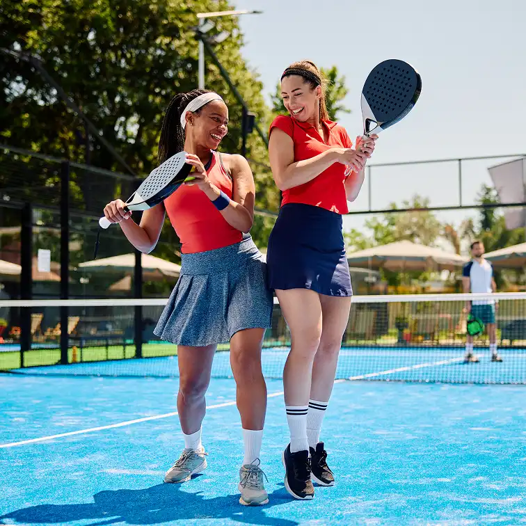 happy women having fun while playing paddle tennis