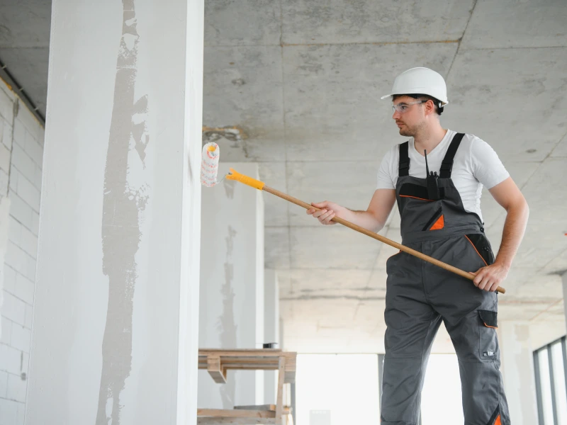 Side view of painter man painting the wall