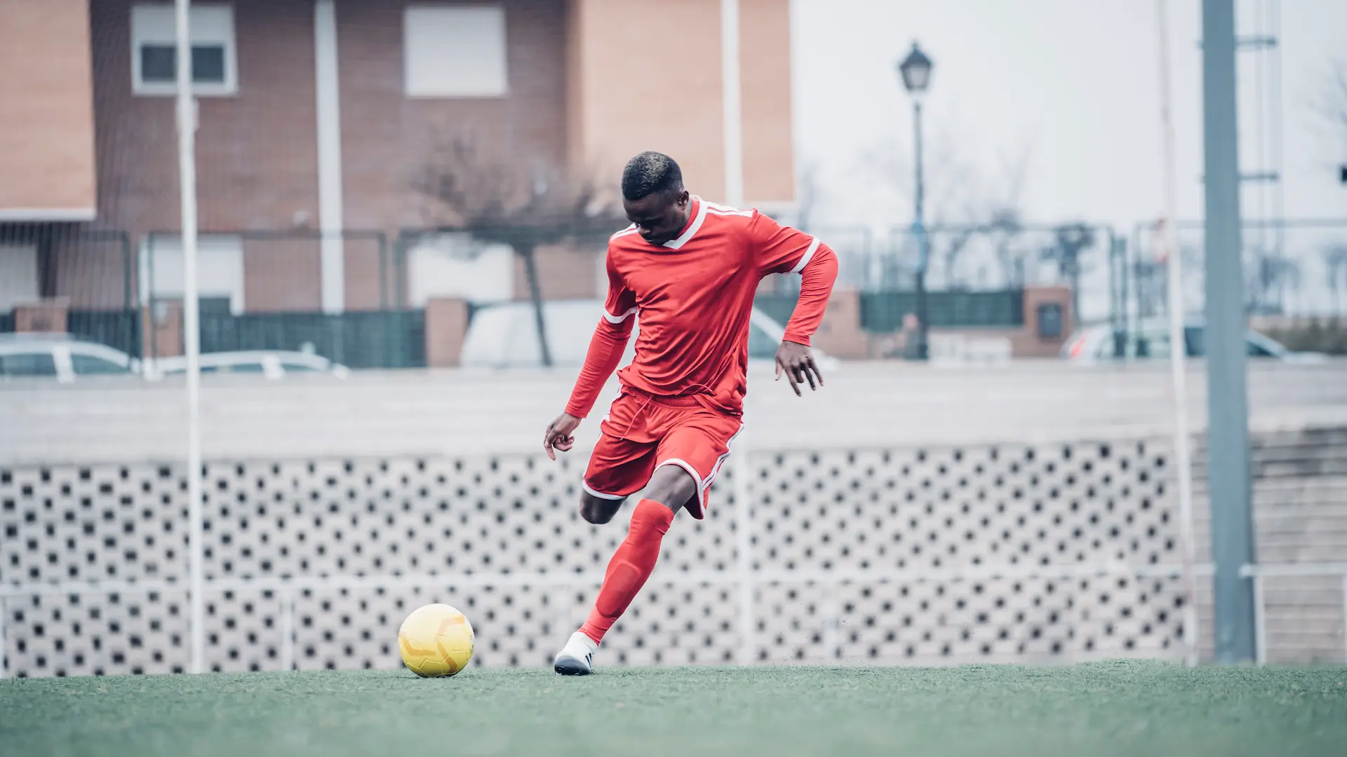 african soccer player with red outfit playing soccer