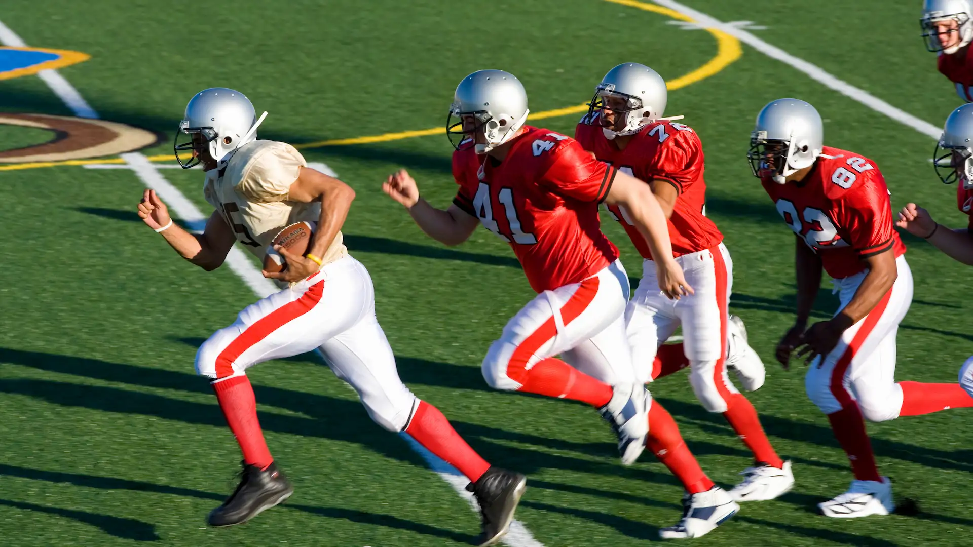 american football players chasing opposing player