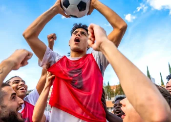 soccer team celebrating victory holding ball up