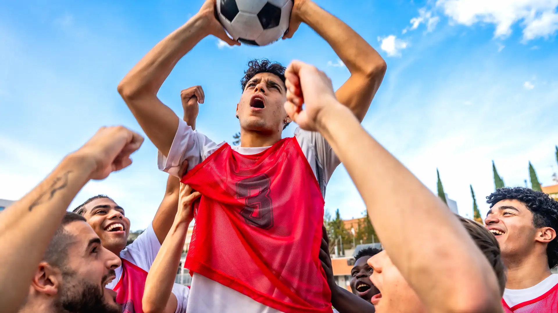 soccer team celebrating victory holding ball up