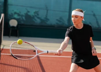 young female tennis player returning