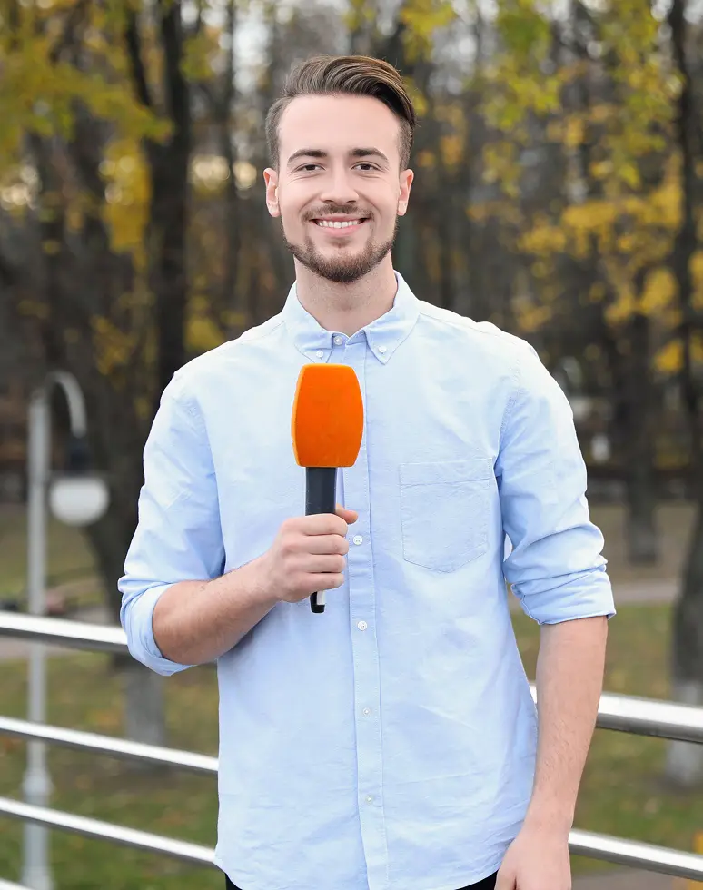 young male journalist with microphone working
