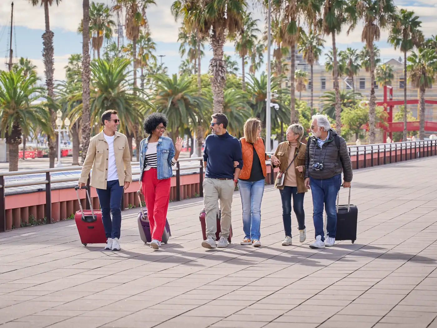 group of mid aged friends walking with their luggage
