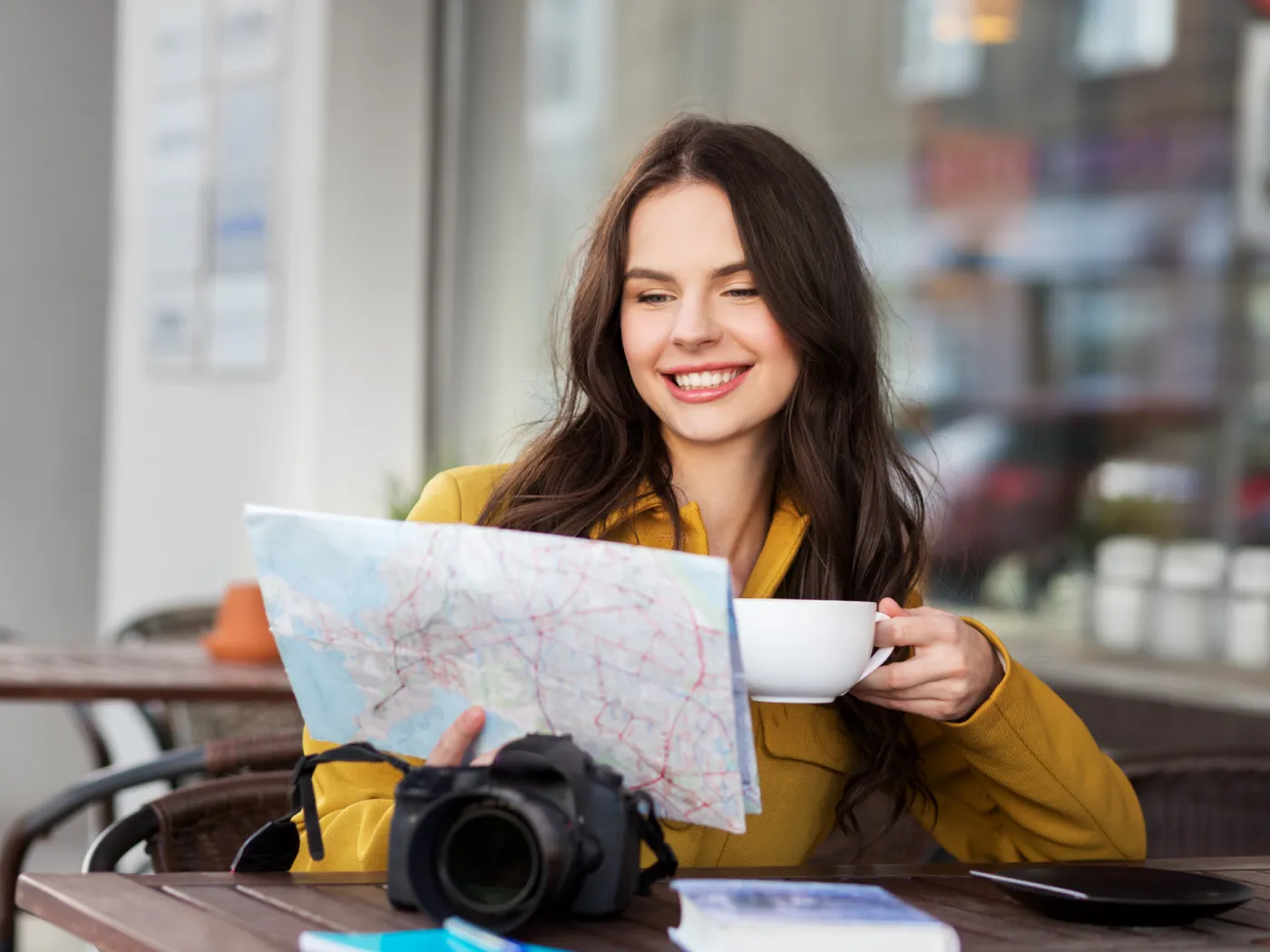 Happy woman travel looking maps while drink coffee