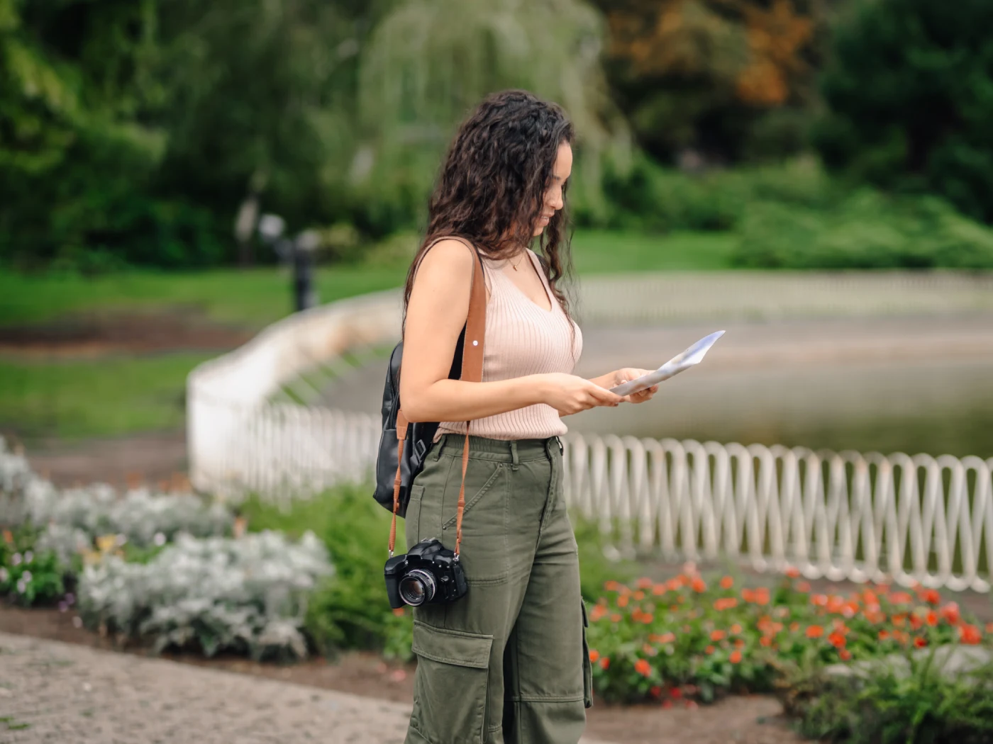 Tourist holding map exploring park with camera